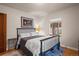 This bedroom features a wooden door and hardwood floors, complemented by a metal bed frame and soft lighting at 1545 Locust St, Denver, CO 80220