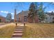 Charming brick home featuring a landscaped front yard, stone steps, and a welcoming entrance at 1545 Locust St, Denver, CO 80220