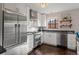 Well-lit kitchen with stainless steel appliances, white cabinetry, dark countertops, and hardwood floors for a modern feel at 1545 Locust St, Denver, CO 80220