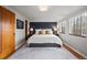 Spacious main bedroom with hardwood floors, a king-sized bed, and bright windows at 1545 Locust St, Denver, CO 80220