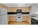 Functional kitchen featuring wood cabinets, white appliances and hardwood floors at 4883 W 68Th Ave # 3, Westminster, CO 80030