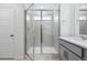 Modern bathroom features glass enclosed shower with light tile surround, light floors, and a white door at 16618 W 92Nd Pl, Arvada, CO 80007