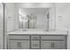 Elegant bathroom featuring a double sink vanity, quartz countertops, and a large frameless mirror at 16618 W 92Nd Pl, Arvada, CO 80007
