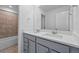 Bathroom featuring double sink vanity, tiled shower, and modern fixtures at 16618 W 92Nd Pl, Arvada, CO 80007