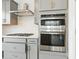 Gourmet kitchen with stainless steel oven, stove, and hood, with a white backsplash at 16618 W 92Nd Pl, Arvada, CO 80007