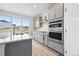 Bright kitchen features stainless steel appliances, gray cabinets, a large island, and a sliding glass door at 16618 W 92Nd Pl, Arvada, CO 80007