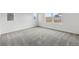 Large open room with neutral carpet, white walls, and three windows offering natural light at 16618 W 92Nd Pl, Arvada, CO 80007