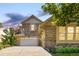 Charming home exterior with stone accents, a well-manicured lawn, and a welcoming driveway at 27565 E Nova Pl, Aurora, CO 80016