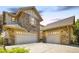 A spacious home with a three-car garage, neutral stone details, and a large driveway at 27565 E Nova Pl, Aurora, CO 80016