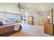 Bright main bedroom with an ensuite bath, large windows, neutral carpet, and a ceiling fan at 27565 E Nova Pl, Aurora, CO 80016