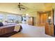 Well-lit main bedroom with large windows offering natural light and neighborhood views, carpet flooring, and ceiling fan at 27565 E Nova Pl, Aurora, CO 80016