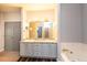 Bathroom with double sinks, granite countertops, and a jetted tub at 9025 W 79Th Way # D, Arvada, CO 80005