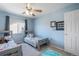 This blue bedroom has two twin beds, a ceiling fan, and a window with natural light at 735 Chesapeake Ave, Monument, CO 80132