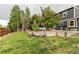 Spacious backyard featuring a lawn, wooden retaining wall, and outdoor seating area by the house at 10109 W Fremont Ave, Littleton, CO 80127