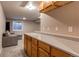 Basement wet bar area with wooden cabinets, sleek countertops, and potential for entertaining at 10109 W Fremont Ave, Littleton, CO 80127