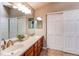 Bathroom featuring double sinks, a vanity with storage, and sliding closet doors at 10109 W Fremont Ave, Littleton, CO 80127