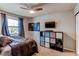 Bedroom with large window, ceiling fan, mounted TV, and a built-in storage cube organizer at 10109 W Fremont Ave, Littleton, CO 80127