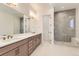Modern bathroom featuring double sinks, a spacious shower with a glass door, and tile flooring at 231 Leafy Aster Ln, Castle Rock, CO 80104