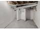 Unfinished basement with exposed ductwork, concrete floors, and doorway at 561 Cherokee St, Denver, CO 80204