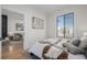 Bright bedroom featuring light wood floors, a bed with decorative pillows, and natural light at 561 Cherokee St, Denver, CO 80204