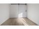 Bedroom featuring light wood floors, white walls and a barn door at 561 Cherokee St, Denver, CO 80204