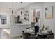 Bright kitchen featuring white cabinets, stainless steel appliances, island, and decorative dining table at 561 Cherokee St, Denver, CO 80204