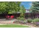Outdoor patio with table and chairs, surrounded by colorful plants and mature trees at 6520 S Newcastle Way, Aurora, CO 80016