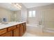 Bathroom featuring a double vanity, bathtub, and glass-enclosed shower at 6520 S Newcastle Way, Aurora, CO 80016