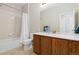 Standard bathroom with a shower-tub combo, oak vanity, and neutral tile flooring at 6520 S Newcastle Way, Aurora, CO 80016