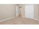 Neutral bedroom with a carpeted floor, white closet doors, and an entry doorway at 6520 S Newcastle Way, Aurora, CO 80016