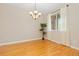 Hardwood dining room with chandelier, large window with curtains, and a decorative potted plant at 6520 S Newcastle Way, Aurora, CO 80016