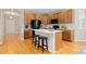 Well-lit kitchen featuring wood cabinets, a center island with seating, and modern black appliances at 6520 S Newcastle Way, Aurora, CO 80016
