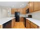 Well-equipped kitchen features oak cabinets, white countertops, and modern black appliances for a sleek, contemporary look at 6520 S Newcastle Way, Aurora, CO 80016