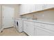 Laundry room featuring a washer, dryer, sink, and storage cabinets at 6520 S Newcastle Way, Aurora, CO 80016