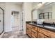 Elegant bathroom featuring a double vanity, stone floors, and a walk-in shower for a spa-like experience at 2716 Dundee Pl, Erie, CO 80516