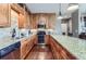 Modern kitchen with stainless appliances, wood cabinets, and large granite island at 2716 Dundee Pl, Erie, CO 80516