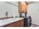 Well-organized laundry room with stainless steel appliances, sink, and storage cabinets at 2716 Dundee Pl, Erie, CO 80516