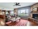 Bright and airy living room with a golf course view and brick fireplace at 2716 Dundee Pl, Erie, CO 80516