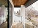 This private balcony features glass railings, wood decking and a tranquil view of surrounding greenery at 1518 S Columbine St, Denver, CO 80210