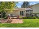 Charming backyard with a brick patio, outdoor seating, a fire pit, and a well-maintained lawn for relaxation and entertaining at 16563 E Kansas Pl, Aurora, CO 80017