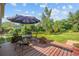 Backyard with deck, an umbrella-covered table, and mature landscaping at 16563 E Kansas Pl, Aurora, CO 80017