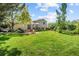 Spacious backyard with a well-manicured lawn, a deck, and a hammock, offering a serene setting for outdoor activities at 16563 E Kansas Pl, Aurora, CO 80017