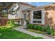 Inviting front entrance with a well-maintained lawn, manicured shrubs, and a brick facade creating a welcoming curb appeal at 16563 E Kansas Pl, Aurora, CO 80017