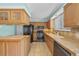 Functional kitchen with wooden cabinets, tile countertops, and essential appliances at 16563 E Kansas Pl, Aurora, CO 80017
