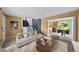 Bright living room with neutral walls, large window, comfortable seating, kitchen and staircase at 16563 E Kansas Pl, Aurora, CO 80017