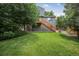 The backyard featuring a green lawn, trees, and a set of stairs leading to an upper level at 611 Branding Iron Ln, Castle Rock, CO 80104