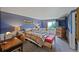 Comfortable bedroom with blue walls, carpet, and large window providing natural light at 611 Branding Iron Ln, Castle Rock, CO 80104