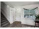 Bright entryway features wood floors, a staircase, and a large window with sheer curtains at 611 Branding Iron Ln, Castle Rock, CO 80104