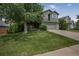 Charming two-story home with a well-manicured lawn and mature shade tree in a suburban neighborhood at 611 Branding Iron Ln, Castle Rock, CO 80104