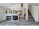 Open-concept living space with a fireplace, staircase and views of the adjacent kitchen area at 611 Branding Iron Ln, Castle Rock, CO 80104